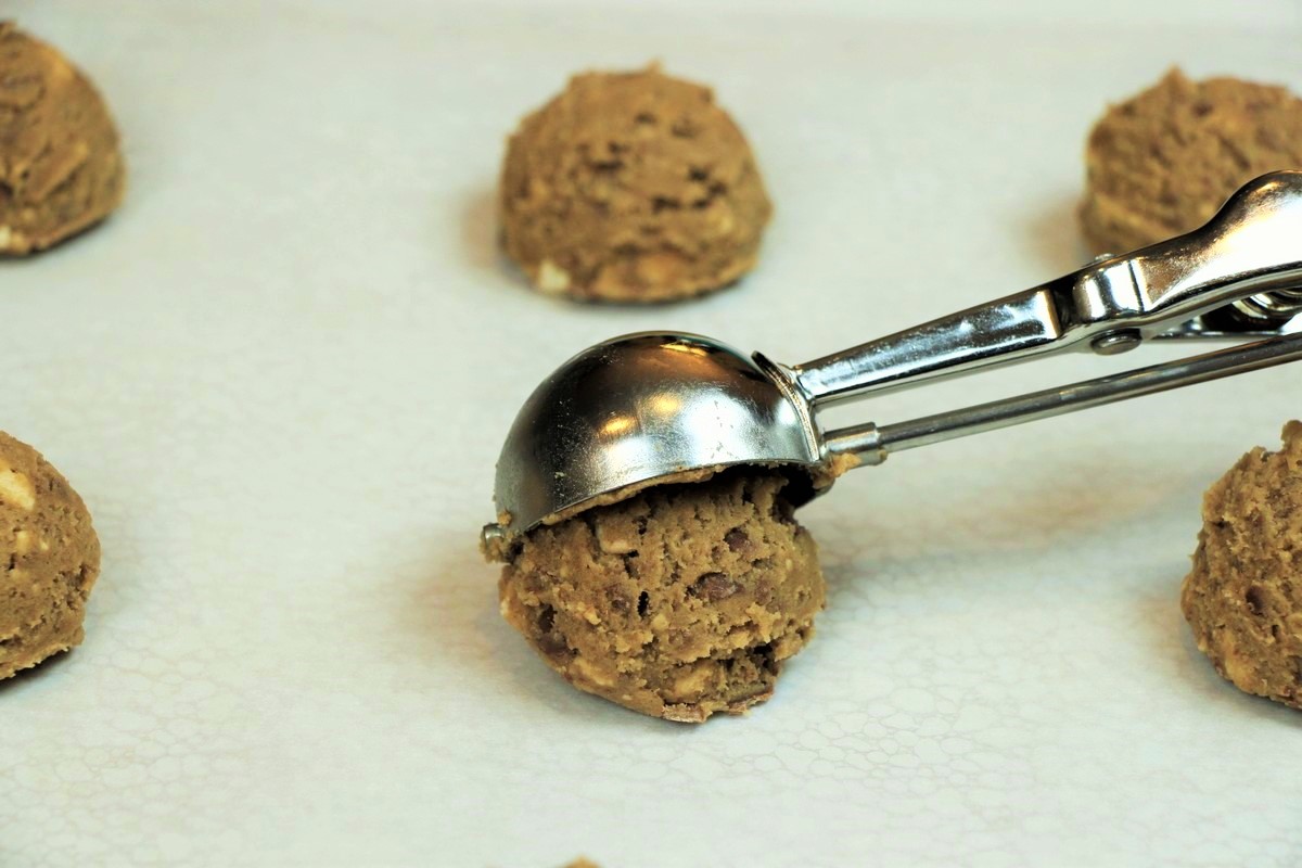 Conveniently shaping cookie dough, using scoop for perfectly round cookies.