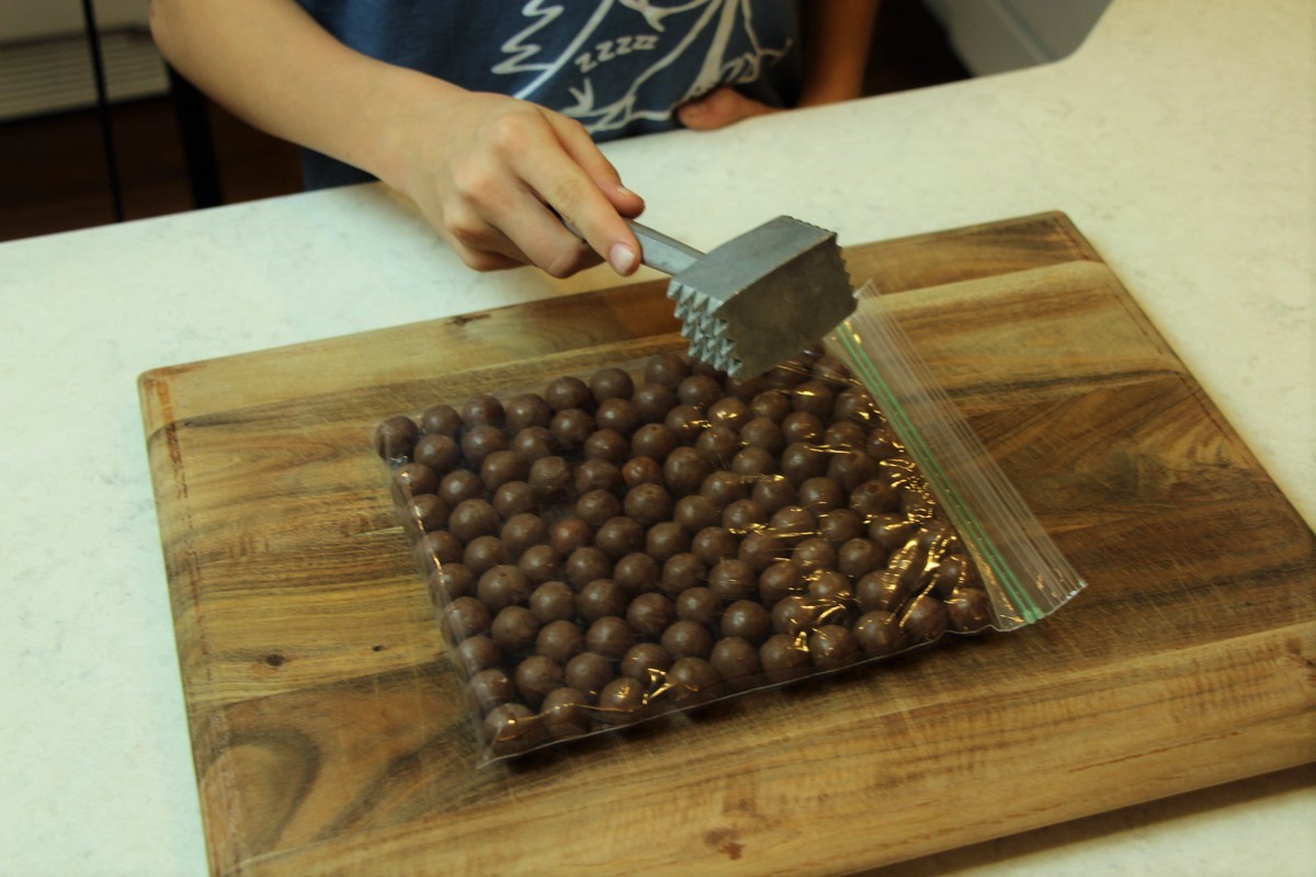Crushing malted milk balls with meat tenderizer.