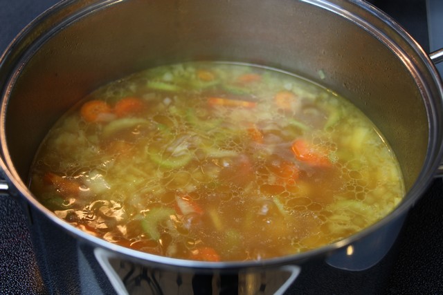 Making soup from stock and vegetables