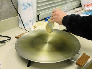 Brushing off flour from lefse griddle