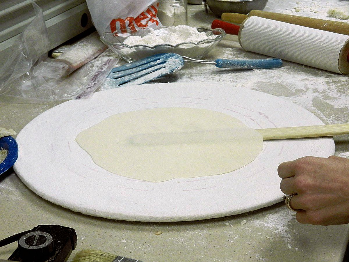 Loosening lefse dough using a wooden stick