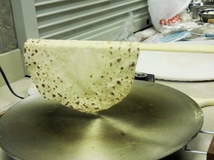 Turning, flipping lefse on griddle