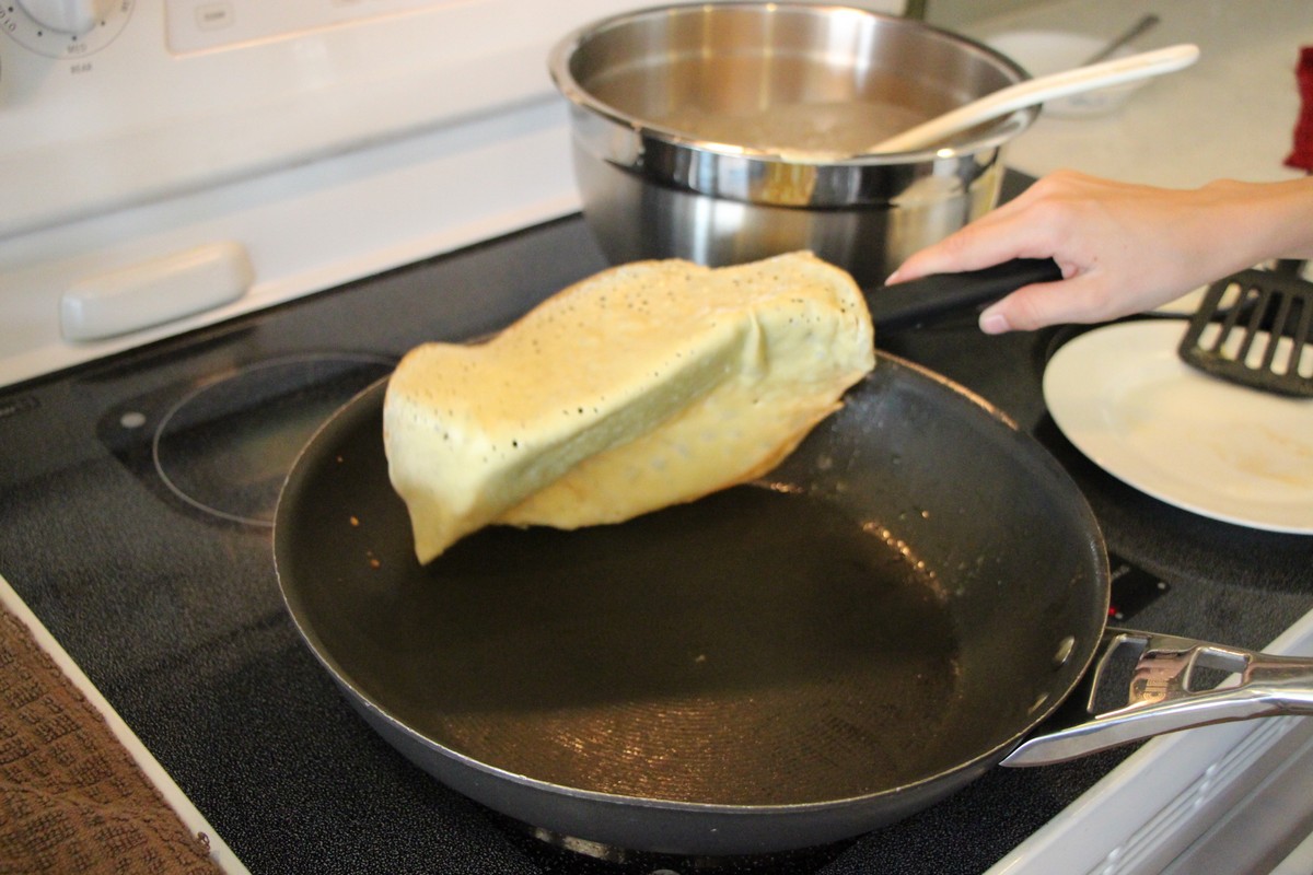 Making thin, authentic Norwegian pancakes, flipping in pan