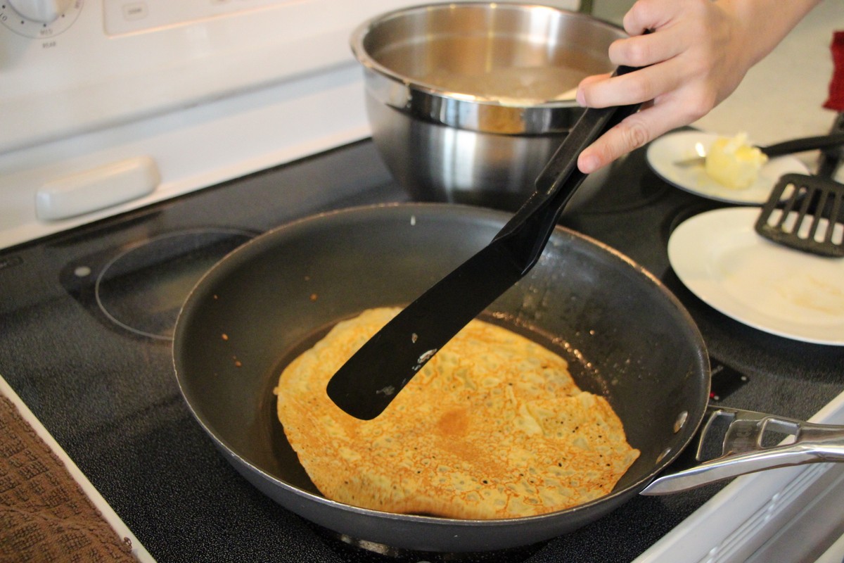 Making thin, authentic Norwegian pancakes, flipping over