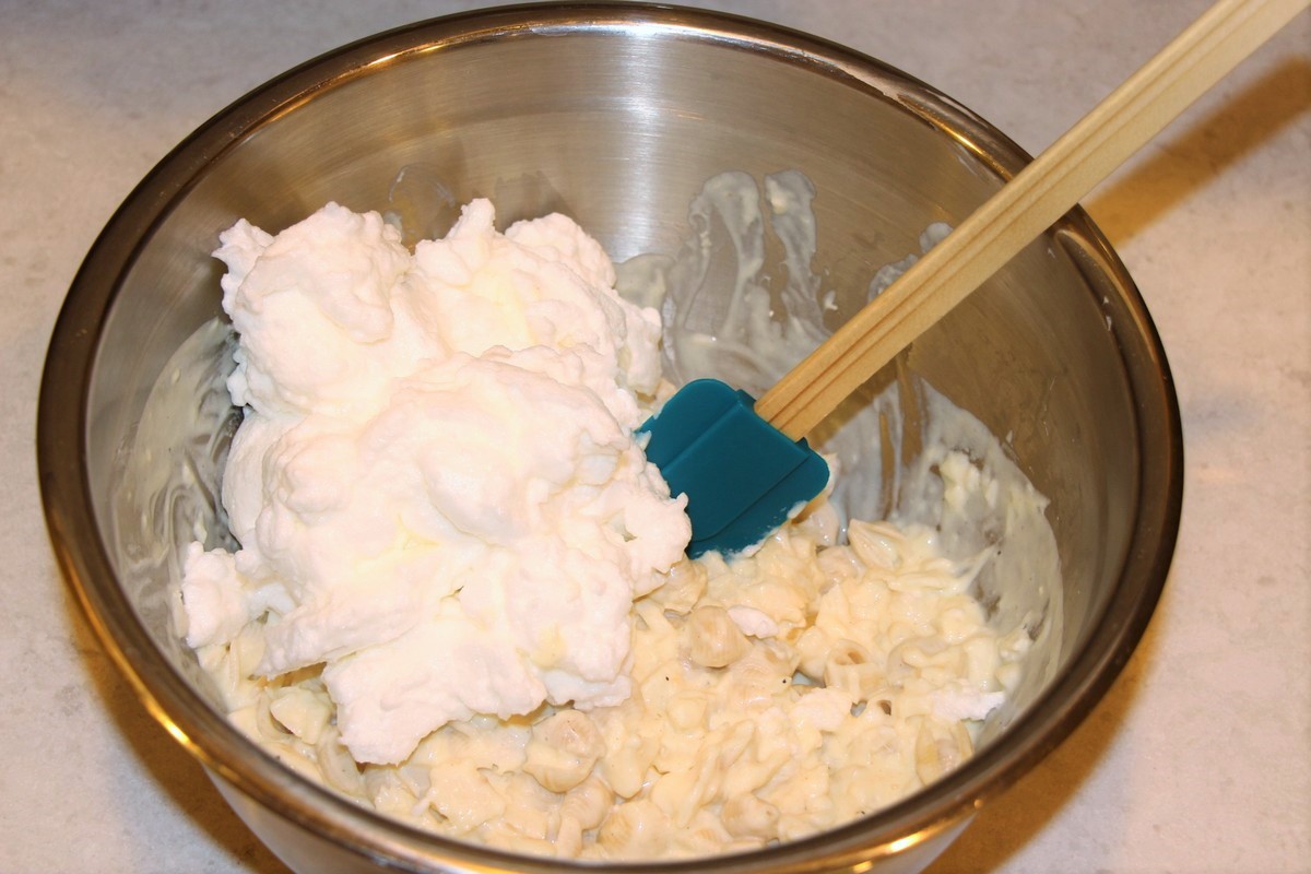 Gently mixing whipped eggwhites into fish casserole, Norwegian fiskegrateng. Recipe and pictures.