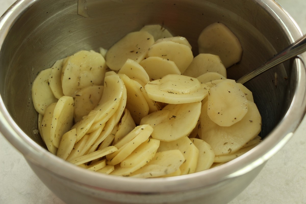 Sliced potatoes, spices, and herbs