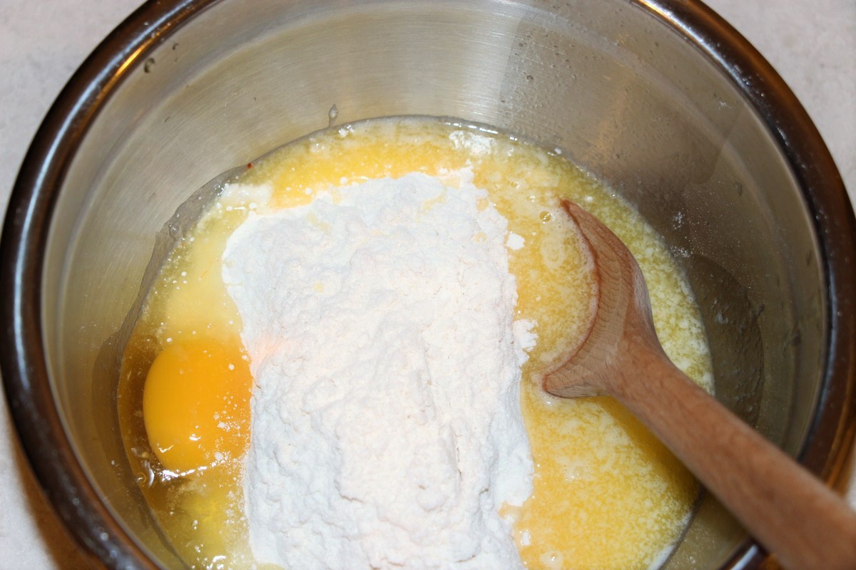 Mixing together ingredients for cake crust in cream cheese sticky bars. Recipe.