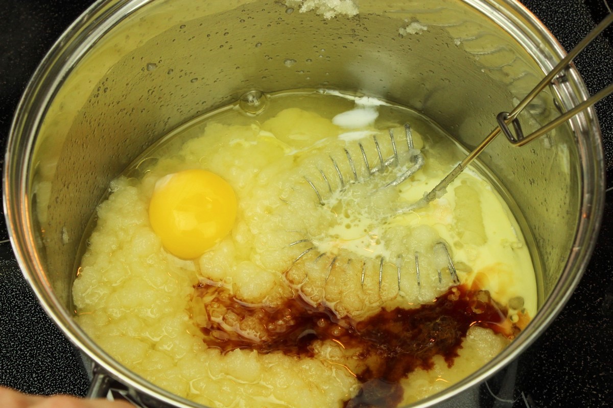 Adding vanilla, egg, and milk to sugar cookies