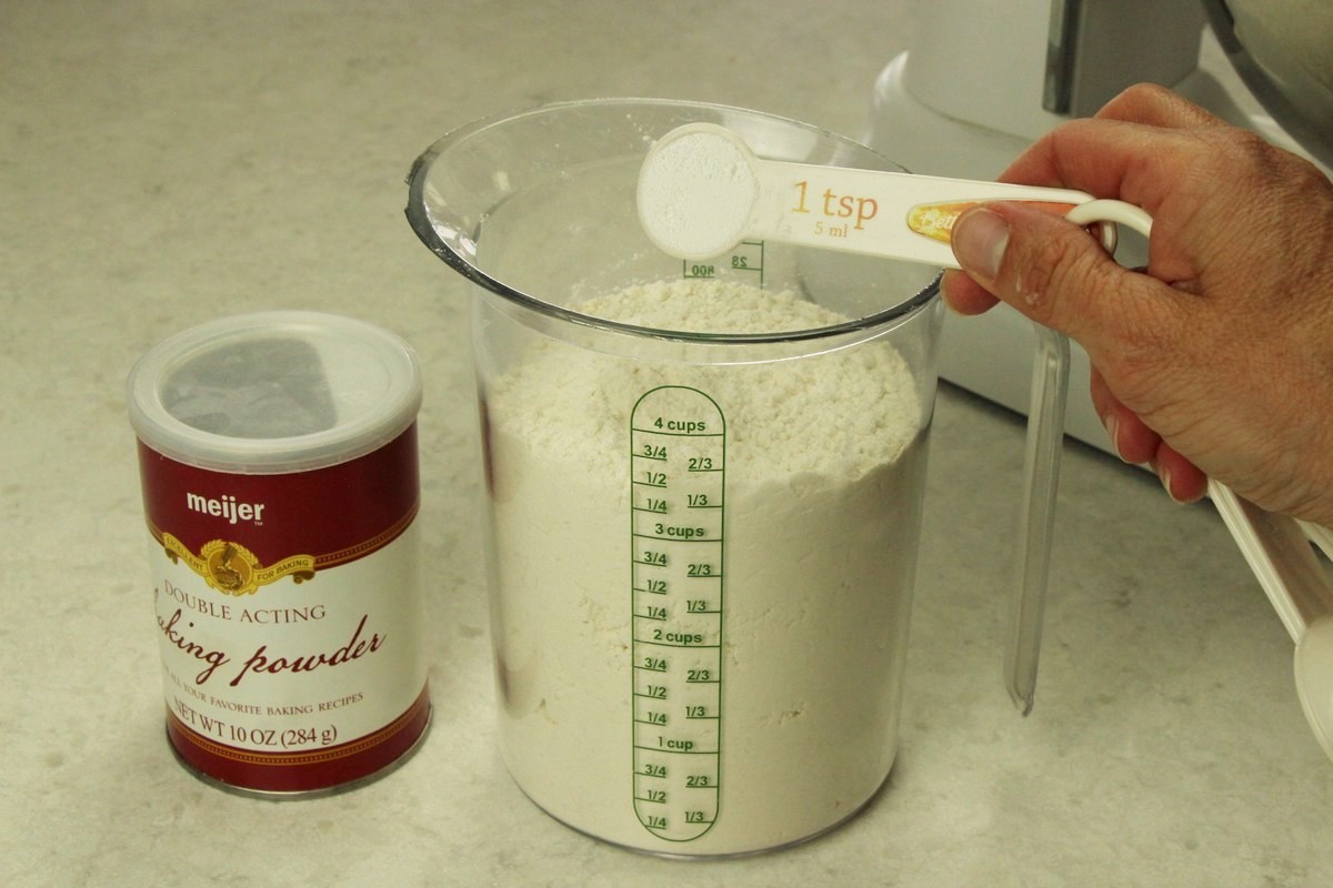 Measuring flour and baking powder for sugar cookie recipe.