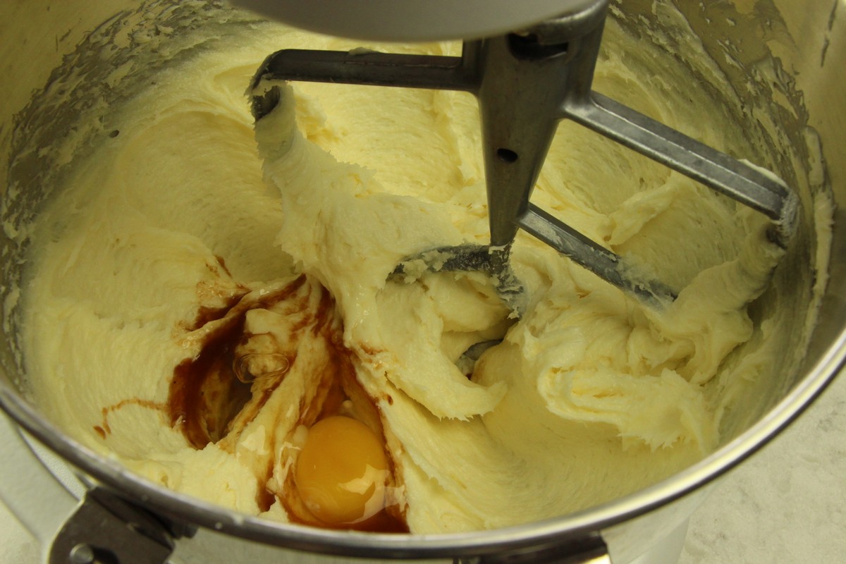Mixing eggs and vanilla into sugar cookie batter.