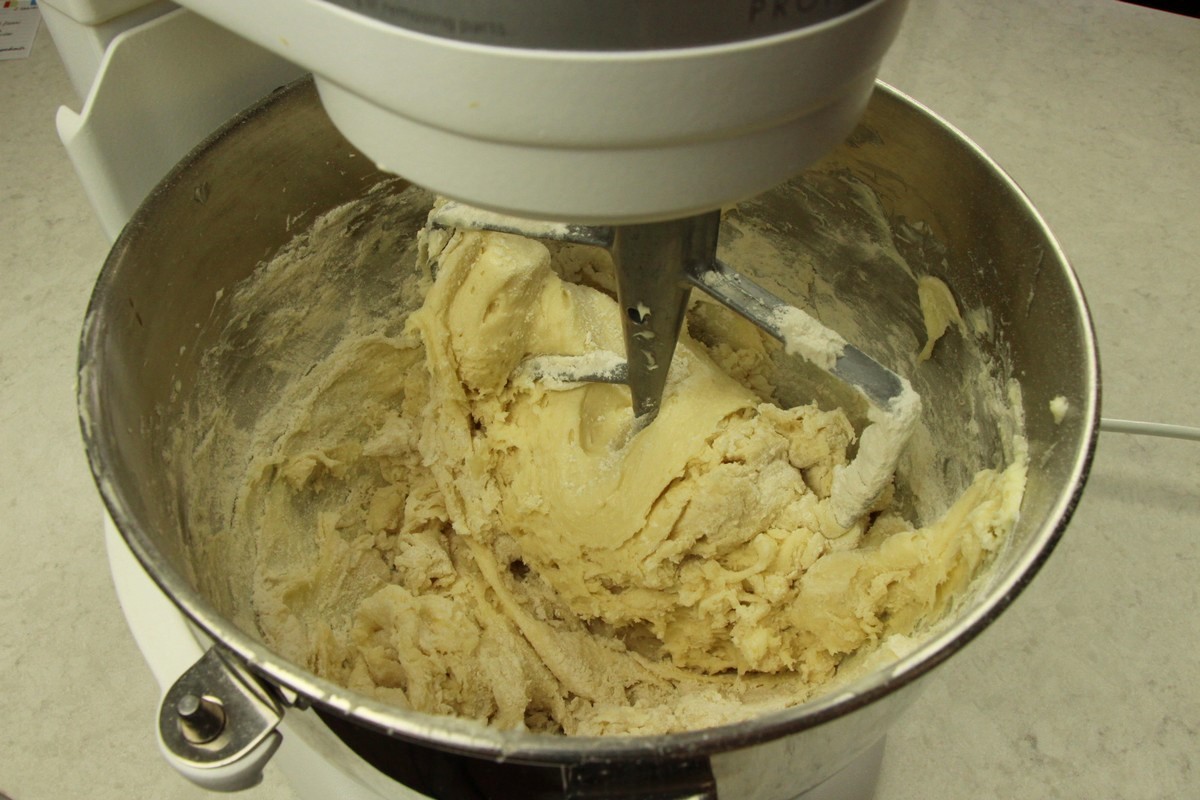 Mixing flour into batter for sugar cookie recipe.
