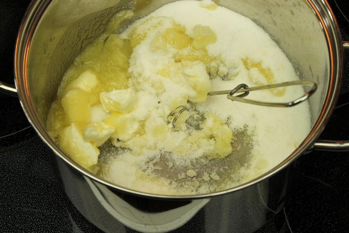 Mixing melted butter, sugar, and cream cheese for chewy sugar cookies.