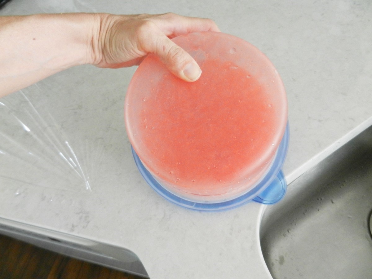 Rinsing tupperware under hot water to release frozen liquid. Pink lemonade jumbo ice cubes. Recipe