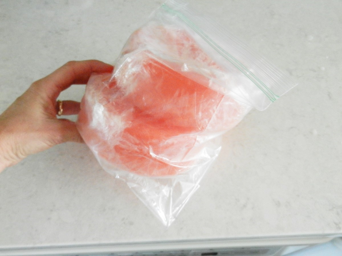 Wrapping jumbo lemonade ice cubes in plastic, storing in zip lock bags. Preparing for huge party. Recipe for cherry lemonade.